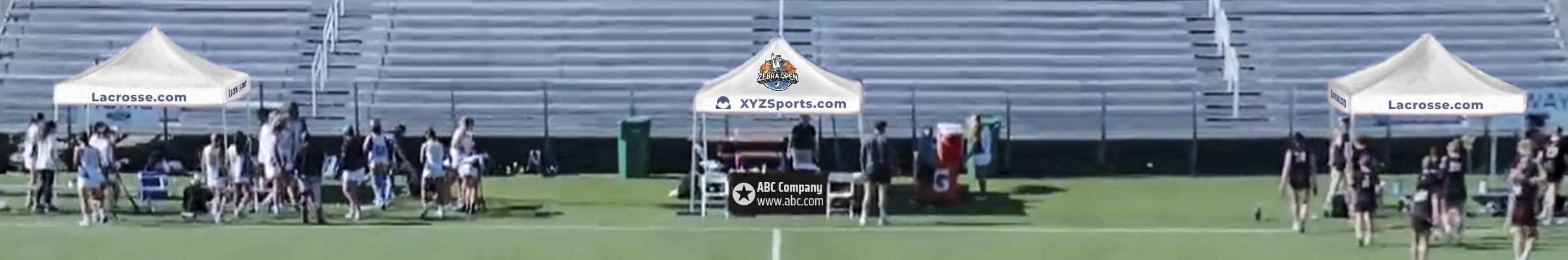 mock-up of a lacrosse field side line with a score keeper table and canopy in the middle and canopies over the two team bench areas